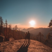 silhouette of man and woman on hill